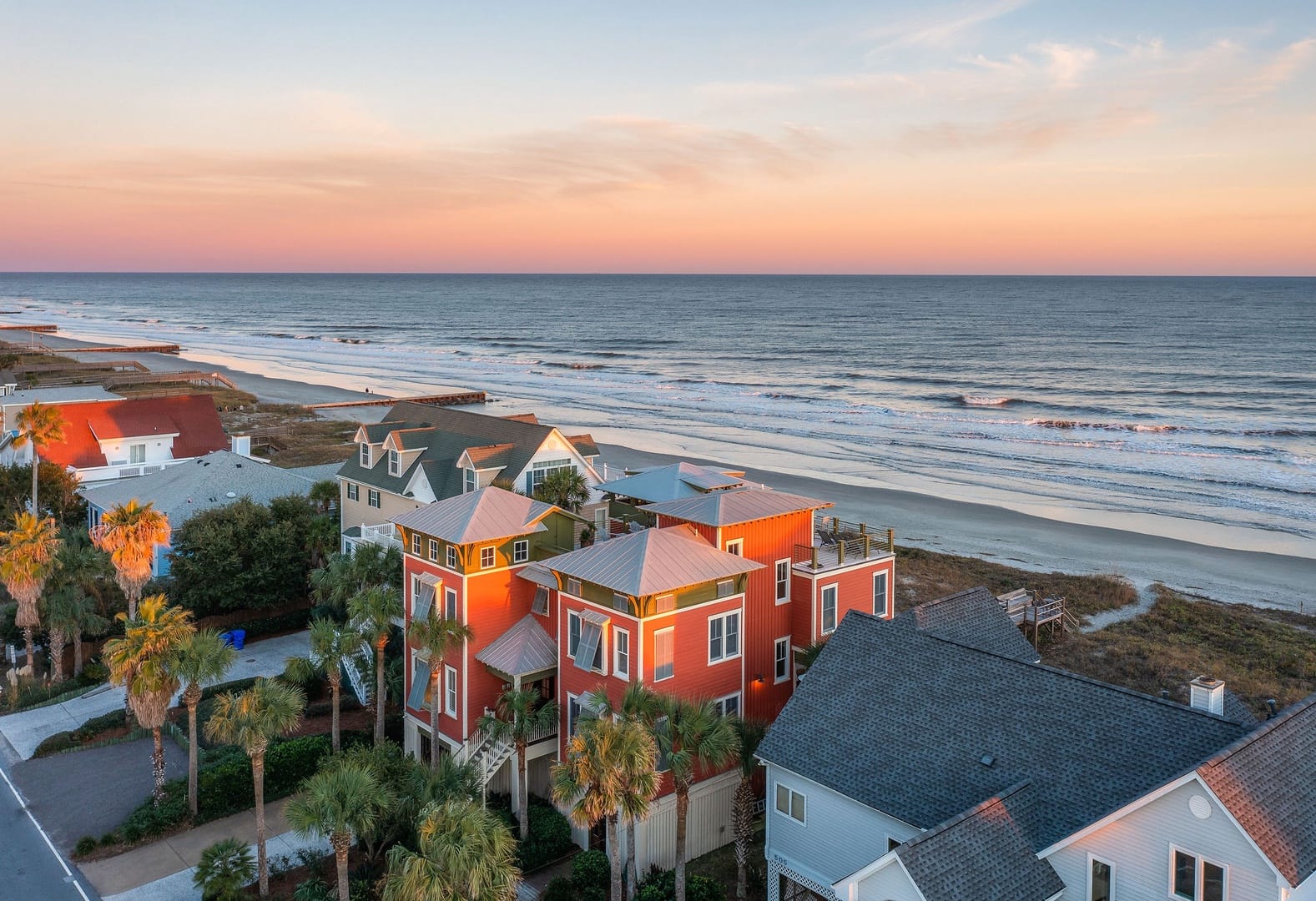 Beachfront houses at sunset, ocean.