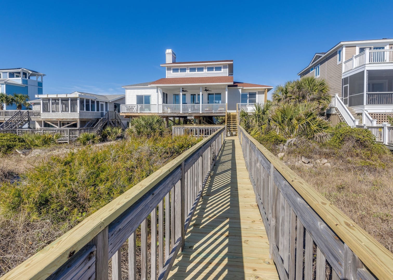 Beach house with wooden walkway.