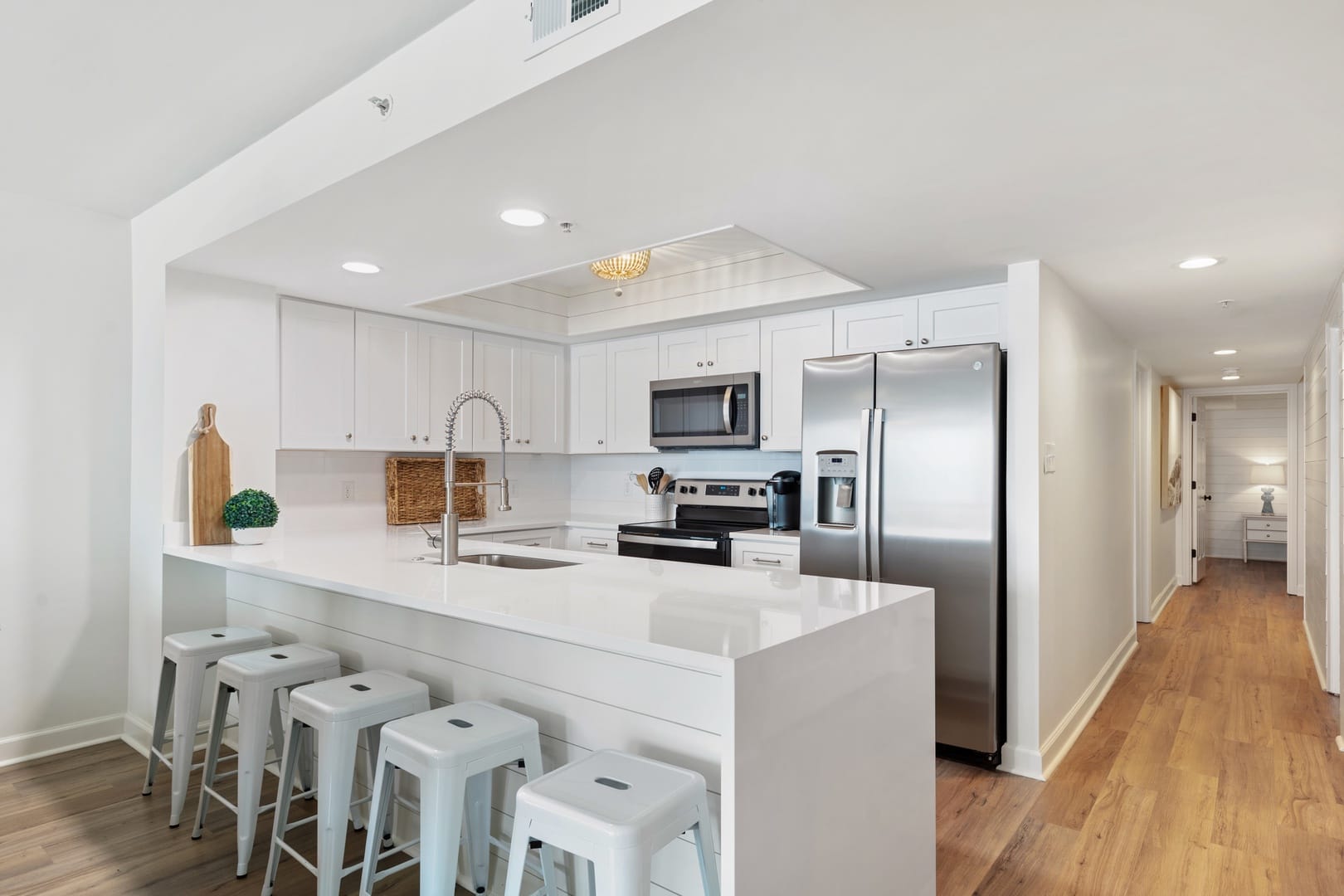 Modern white kitchen with bar stools.