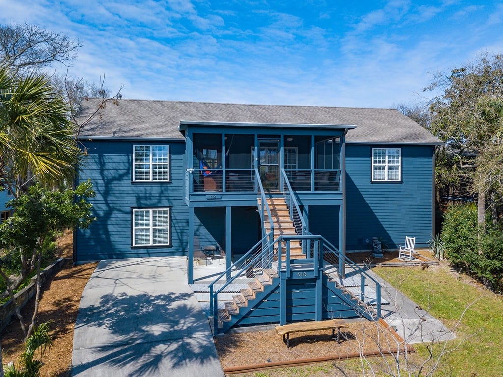 Two-story blue house with stairs.