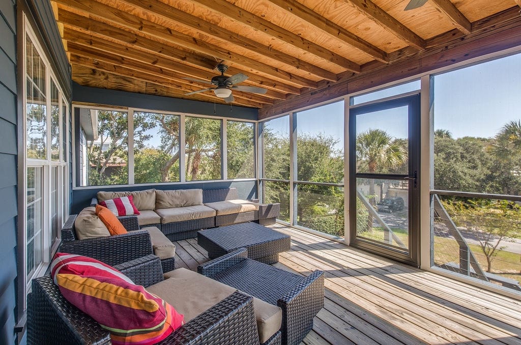 Screened porch with wicker furniture.