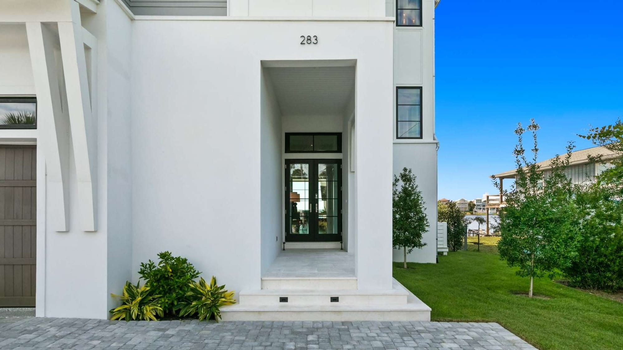 Modern house entrance with green plants.