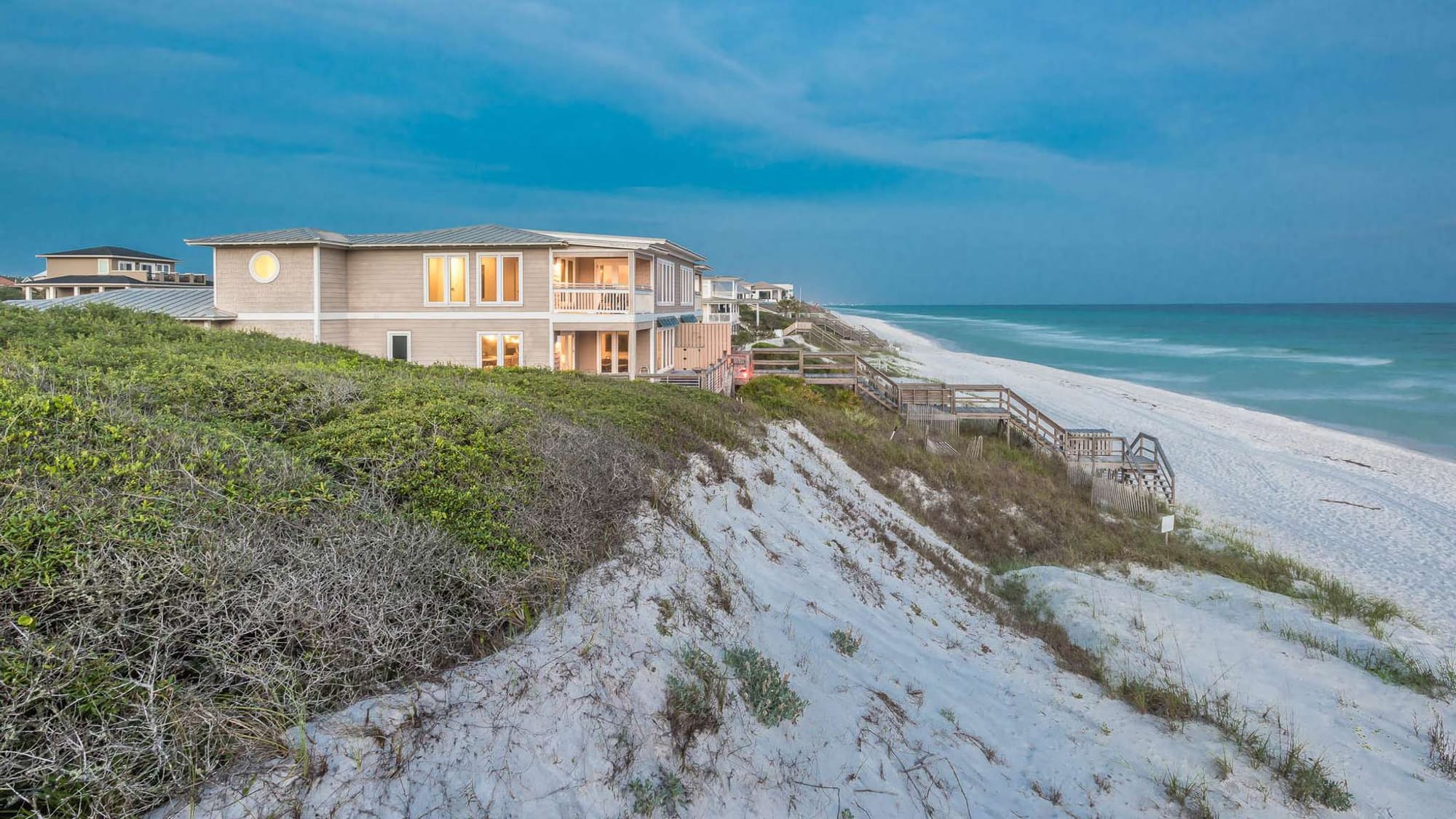 Beach house overlooking sandy shoreline.