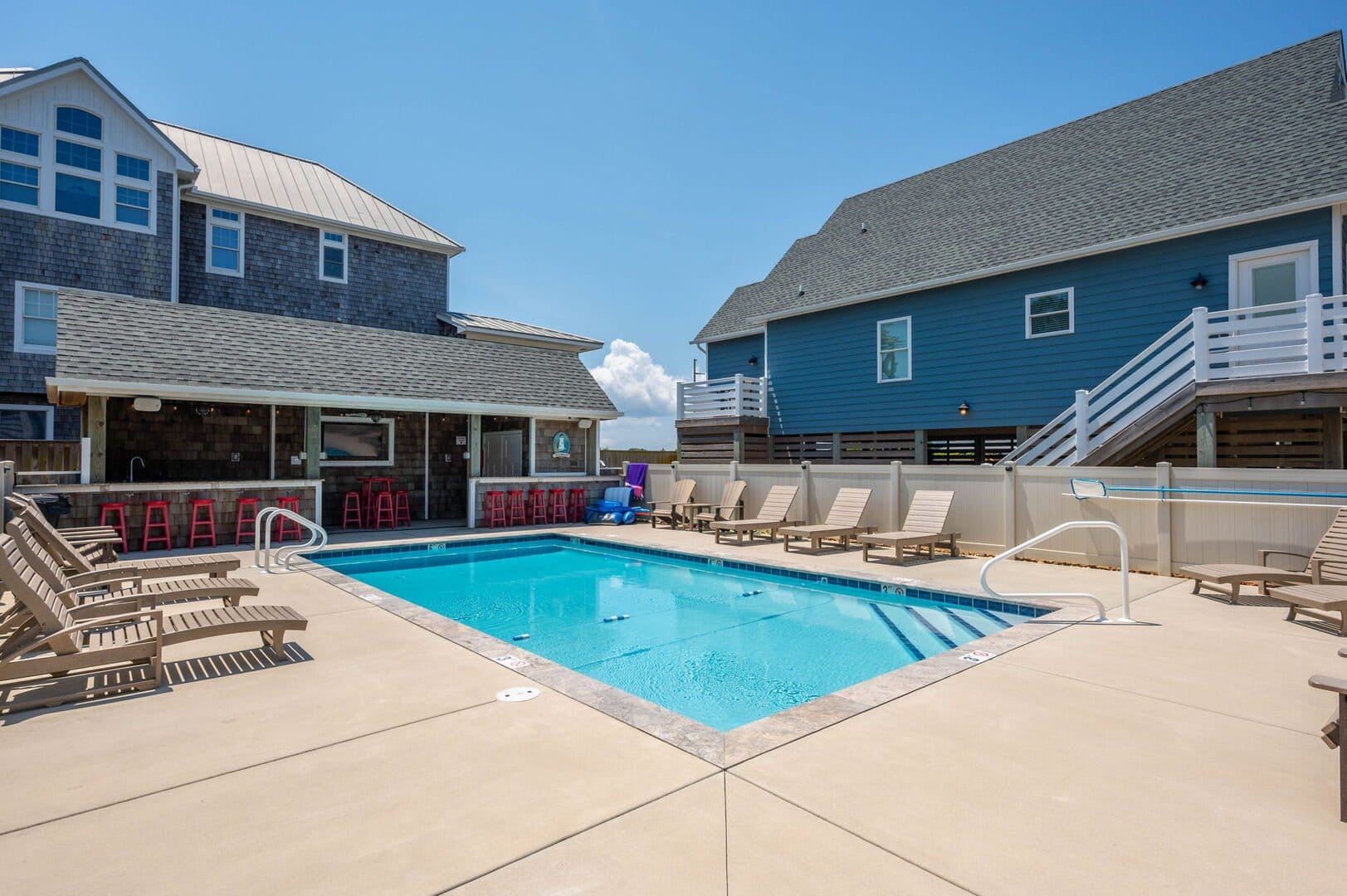 Outdoor pool with chairs and bar.