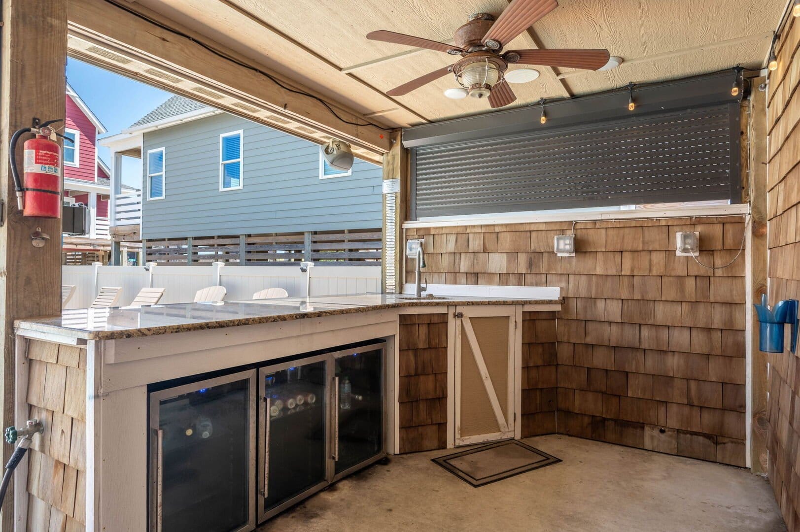 Outdoor kitchen with ceiling fan.