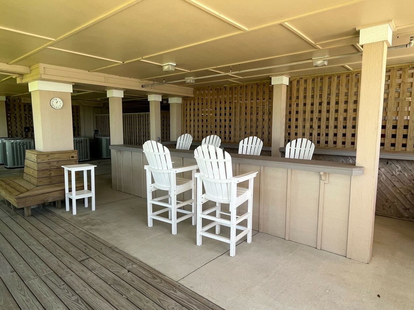 Outdoor bar with white chairs.