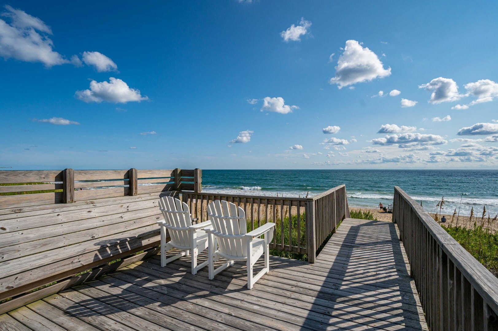 Two chairs on wooden deck.