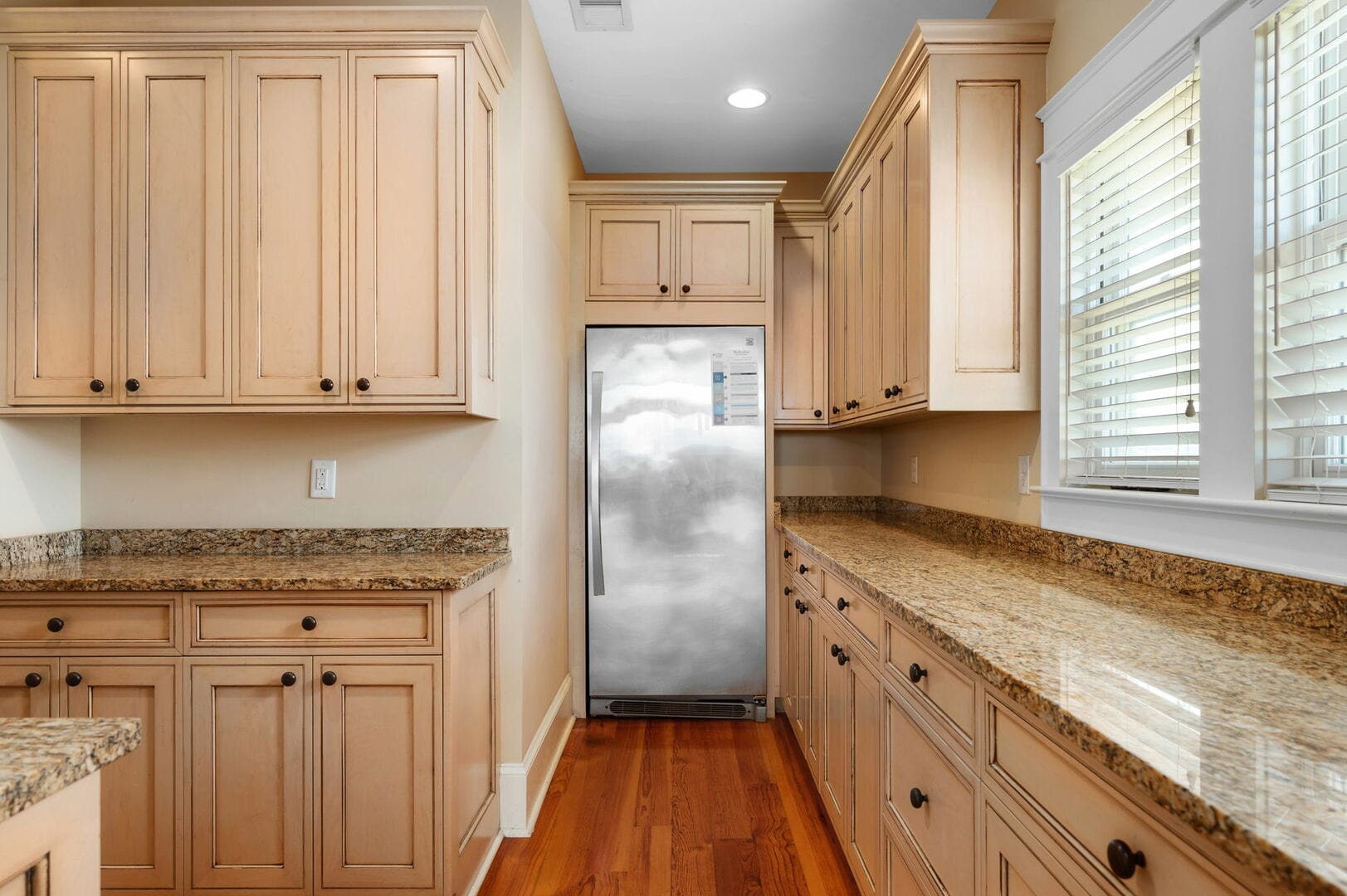 Wood cabinets, granite countertops, stainless fridge.