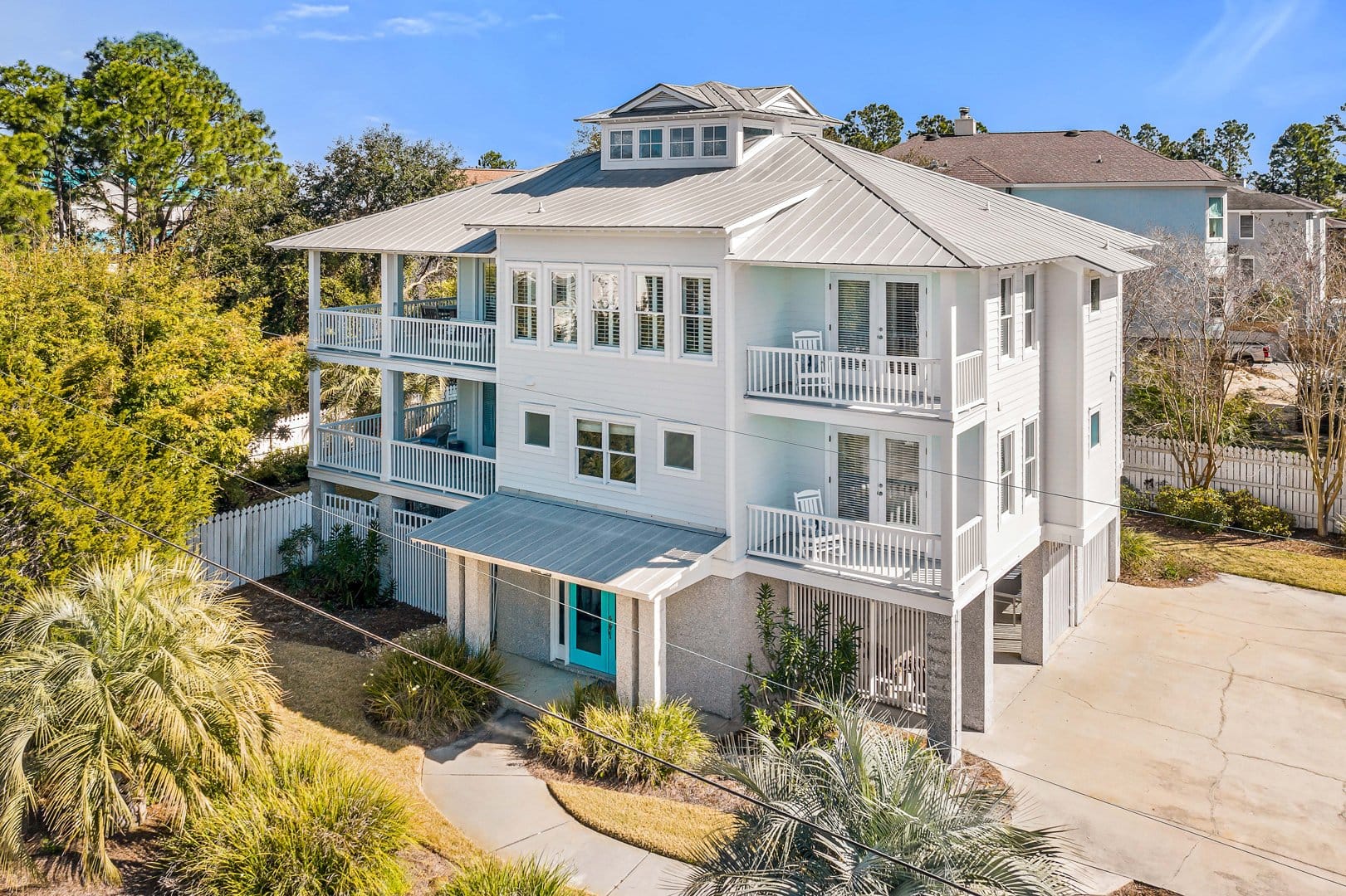 Three-story white house with balconies.