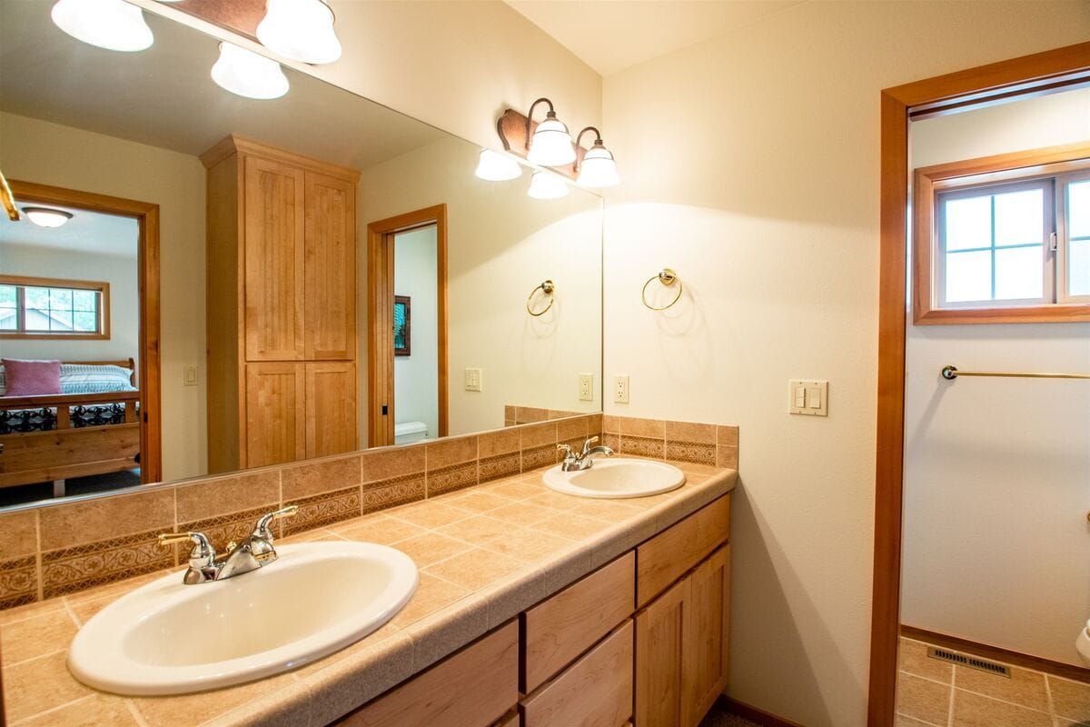 Bathroom with double sinks, mirror.