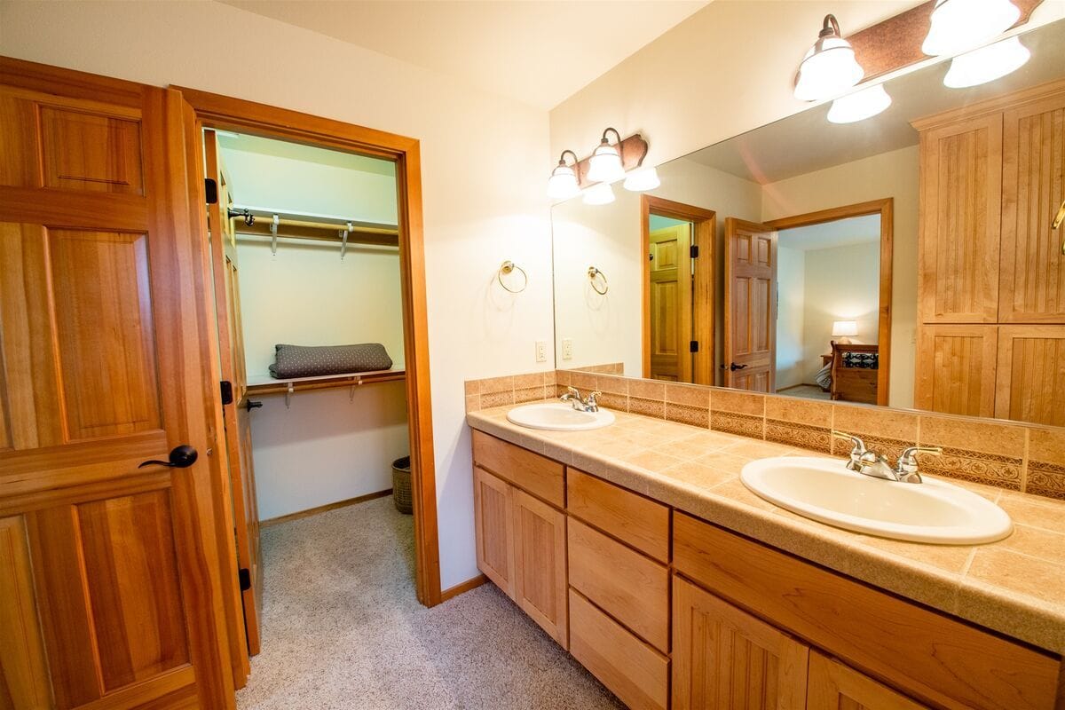 Bathroom with double sinks and closet.