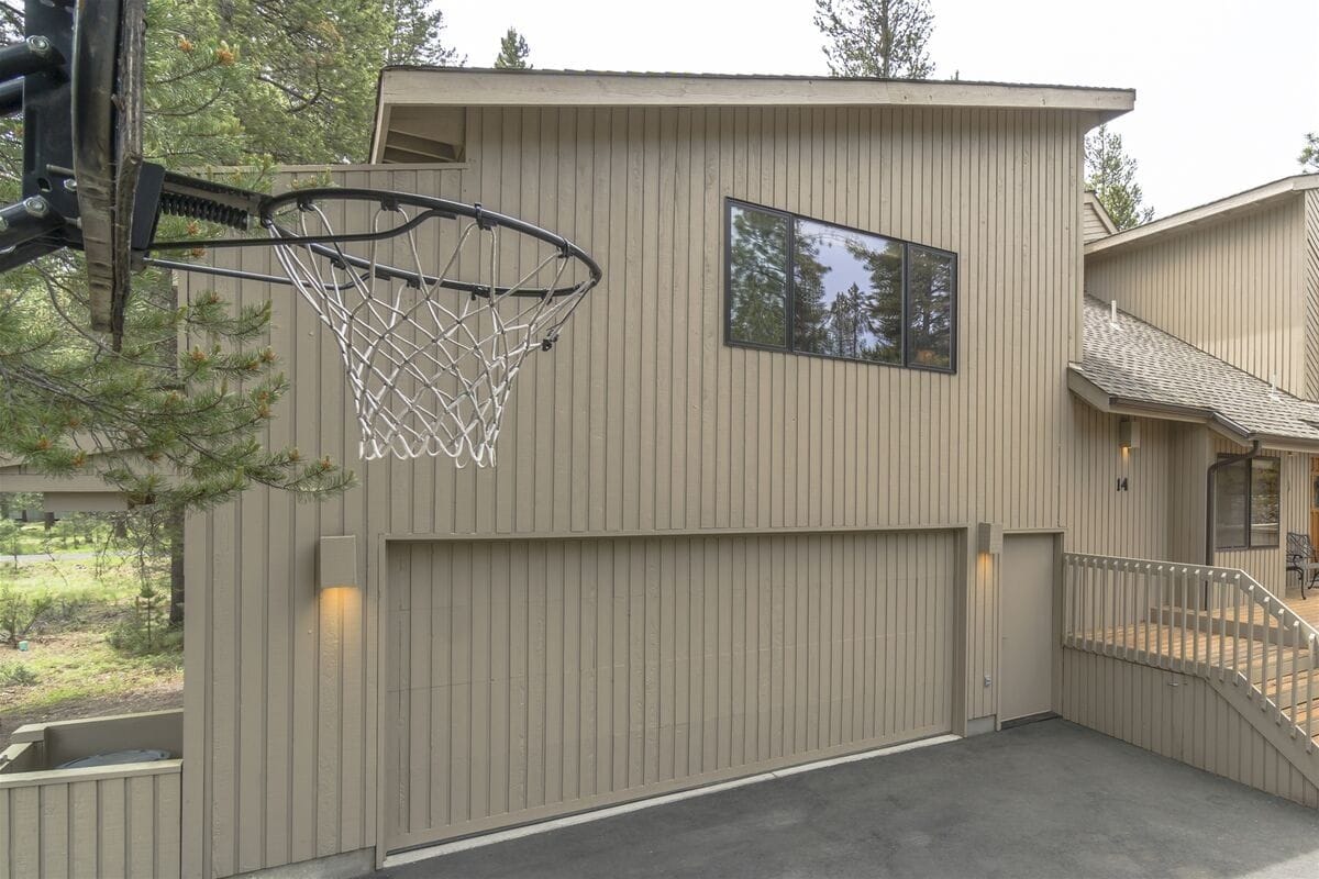 Basketball hoop outside beige house.