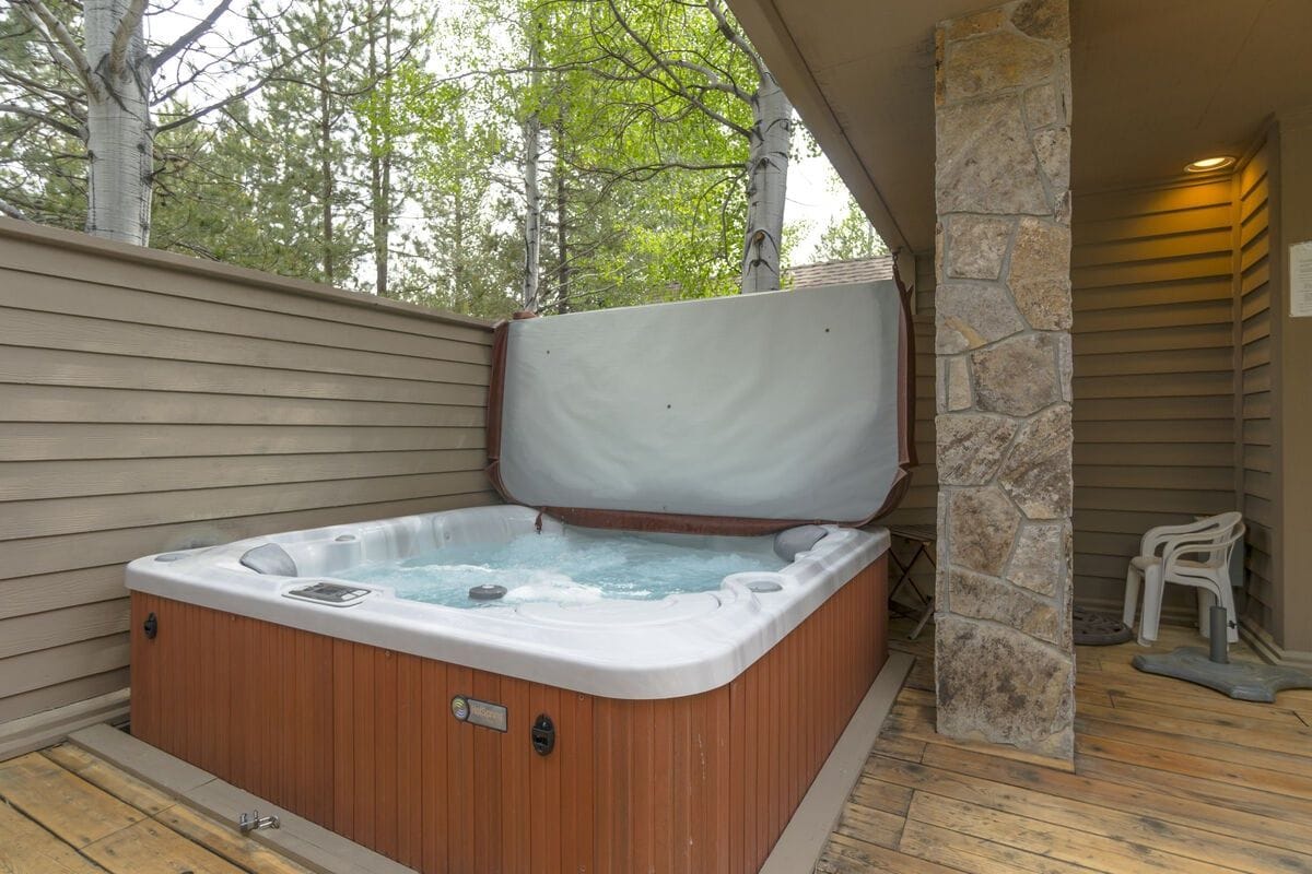 Outdoor hot tub on wooden patio.