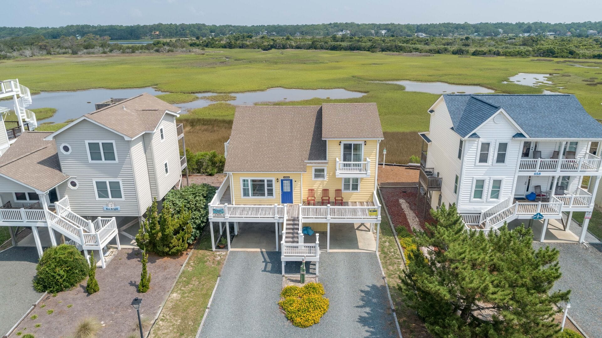 Coastal houses with marshland backdrop.