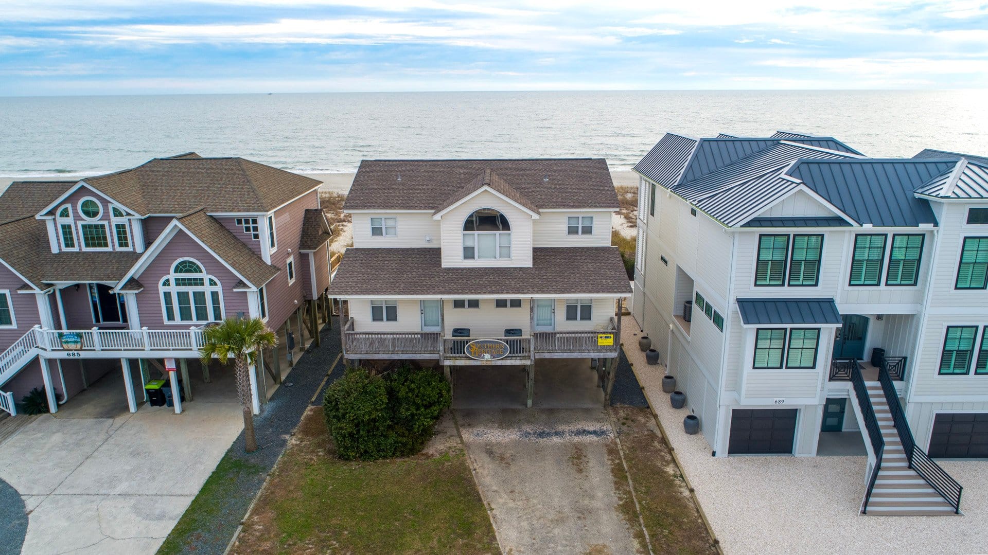 Three beach houses by the ocean.