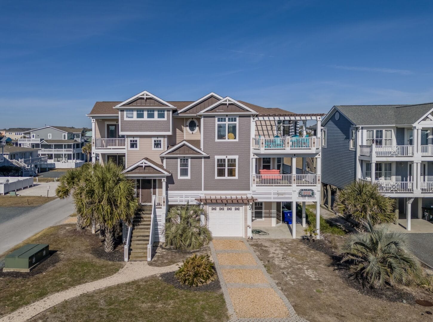 Large beach house with palm trees.