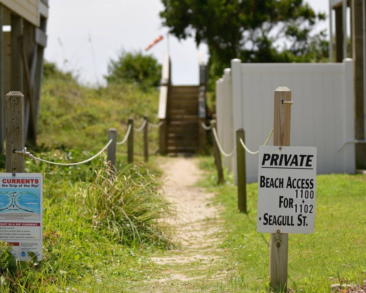 Private beach access with signs.