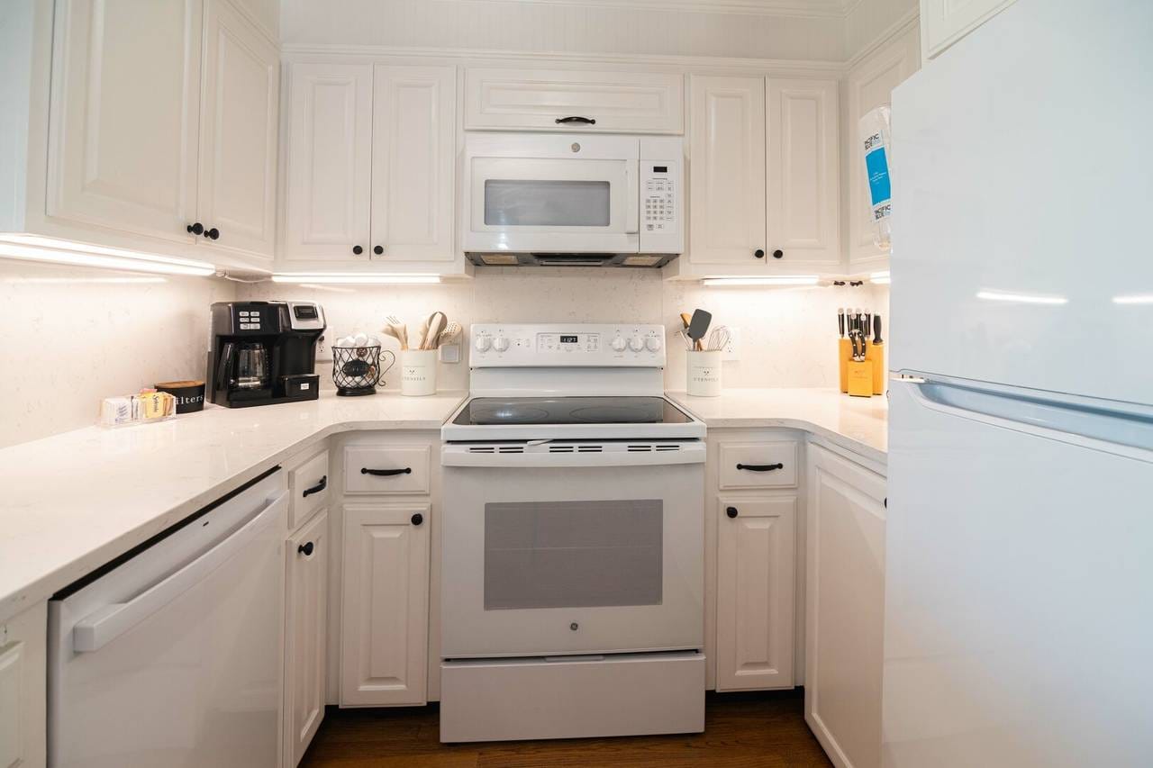 White kitchen with appliances and cabinets.