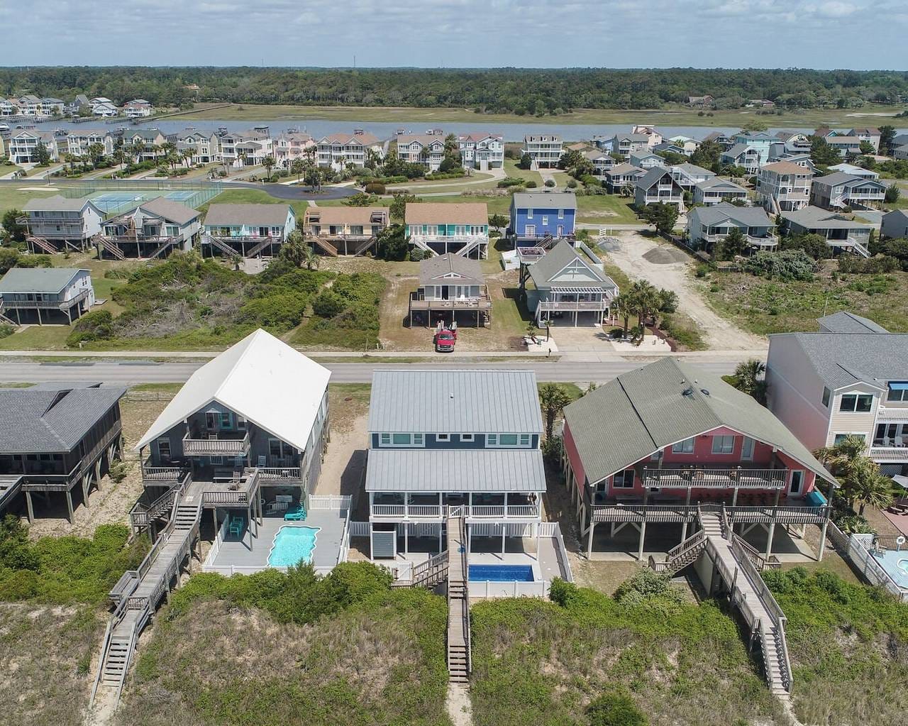 Beachfront houses with pools, aerial.