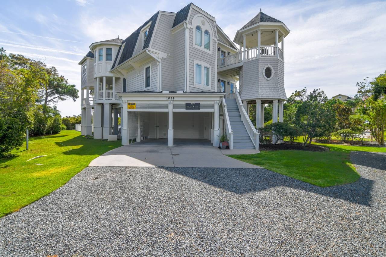 Gray house with turret and driveway.