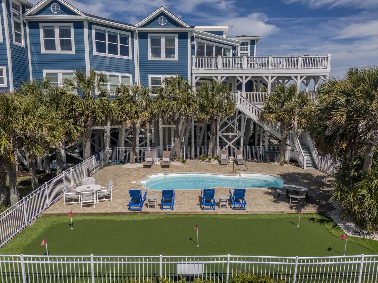 Blue house, pool, palm trees, mini-golf.