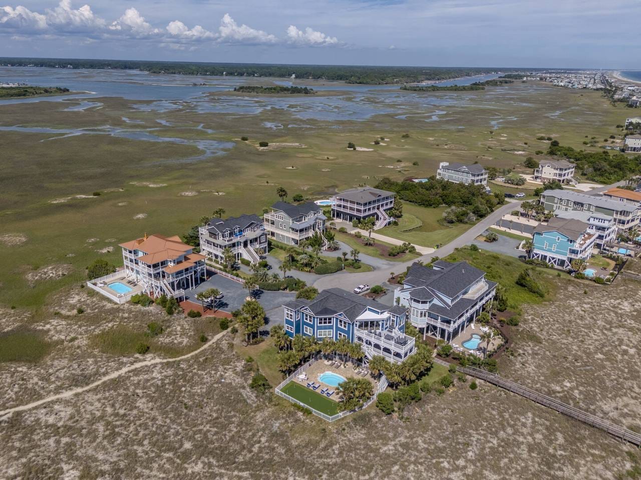 Coastal homes by marshland, aerial view.