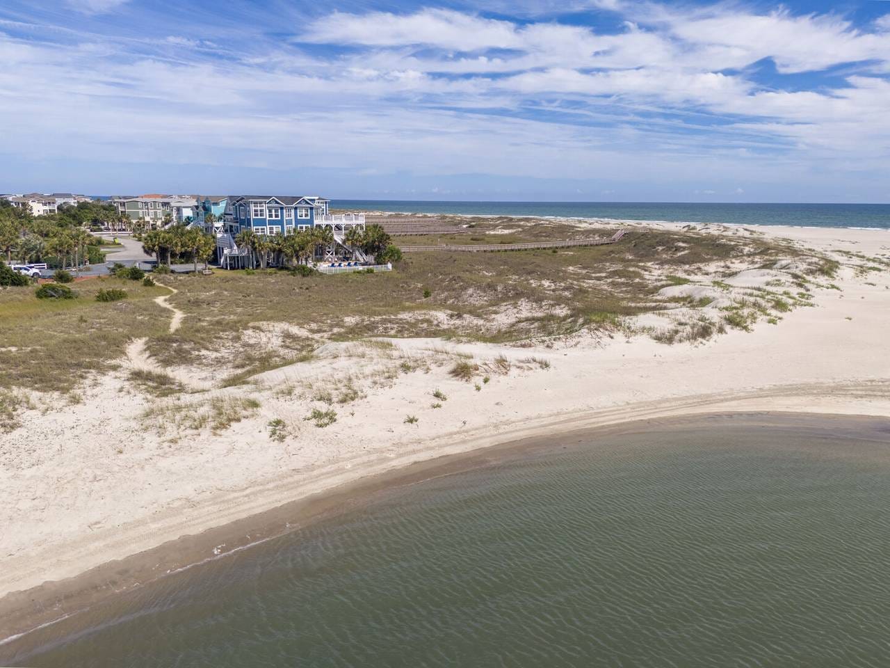 Beachfront view with houses, dunes.