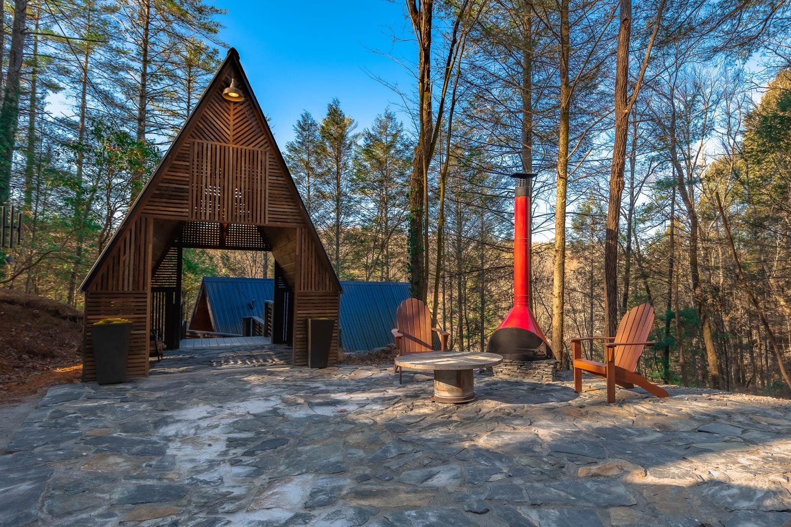 Cabin and chairs in forest.