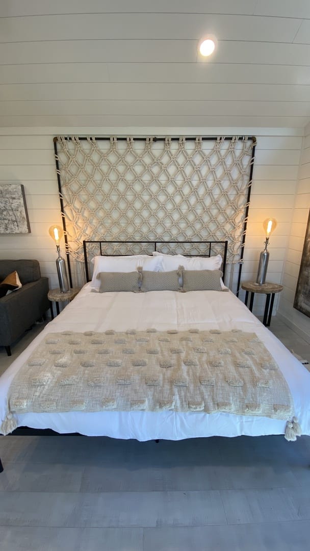 Bedroom with patterned headboard, lighting.