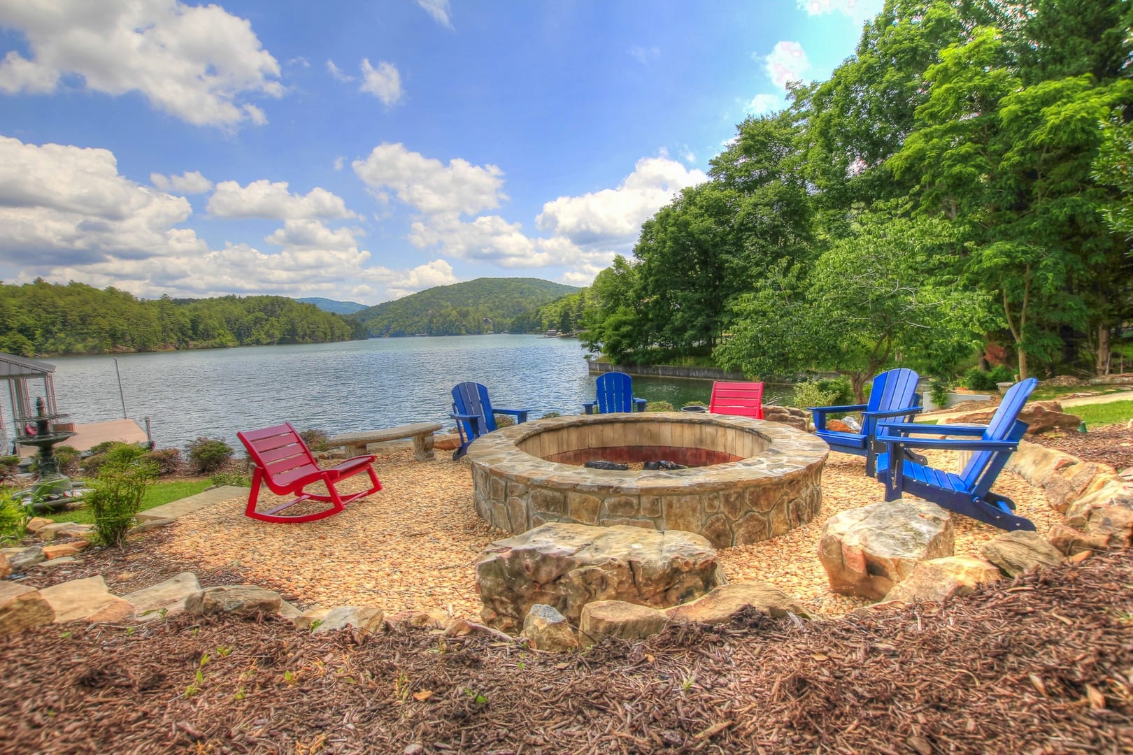 Lakeside fire pit with chairs.