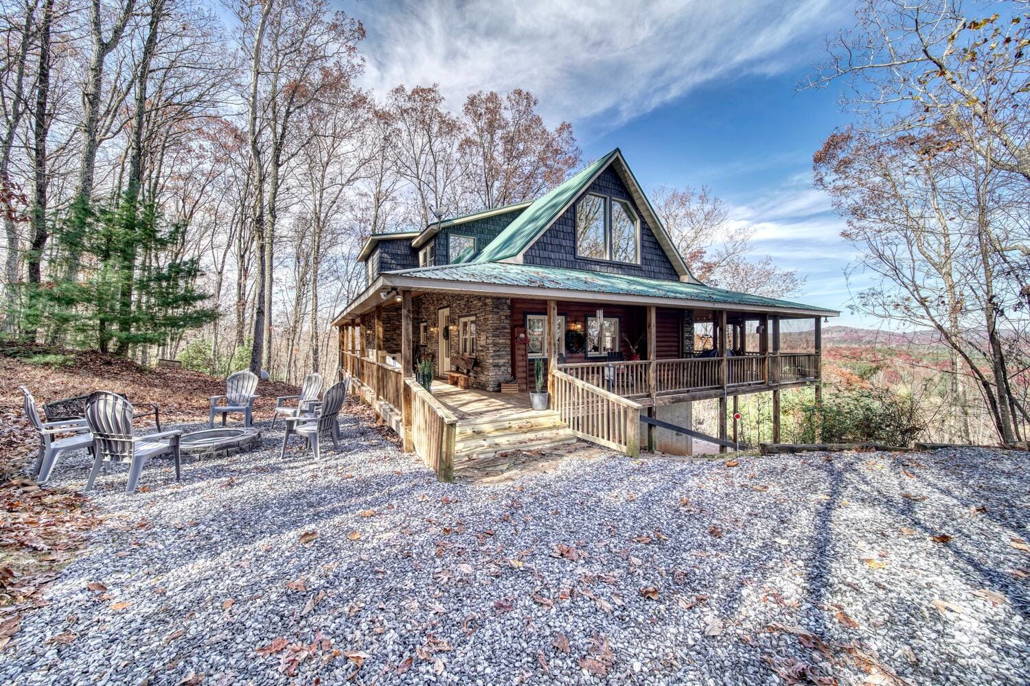 Cabin with porch in wooded area.