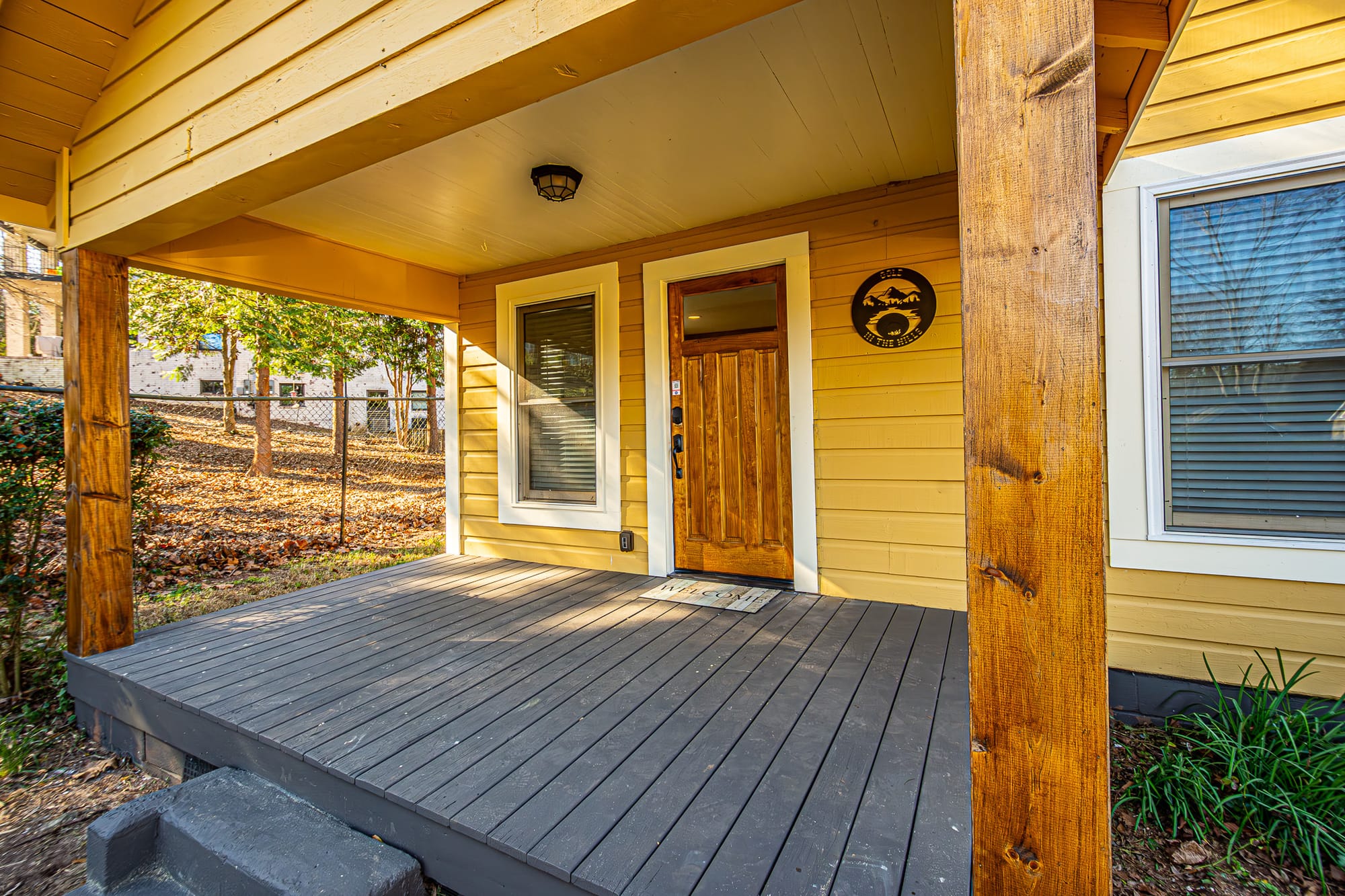 Yellow house porch with wooden door.