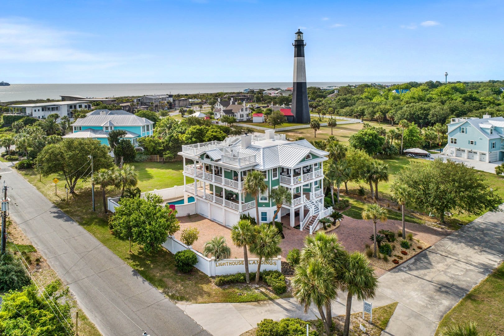 Coastal house with lighthouse nearby.