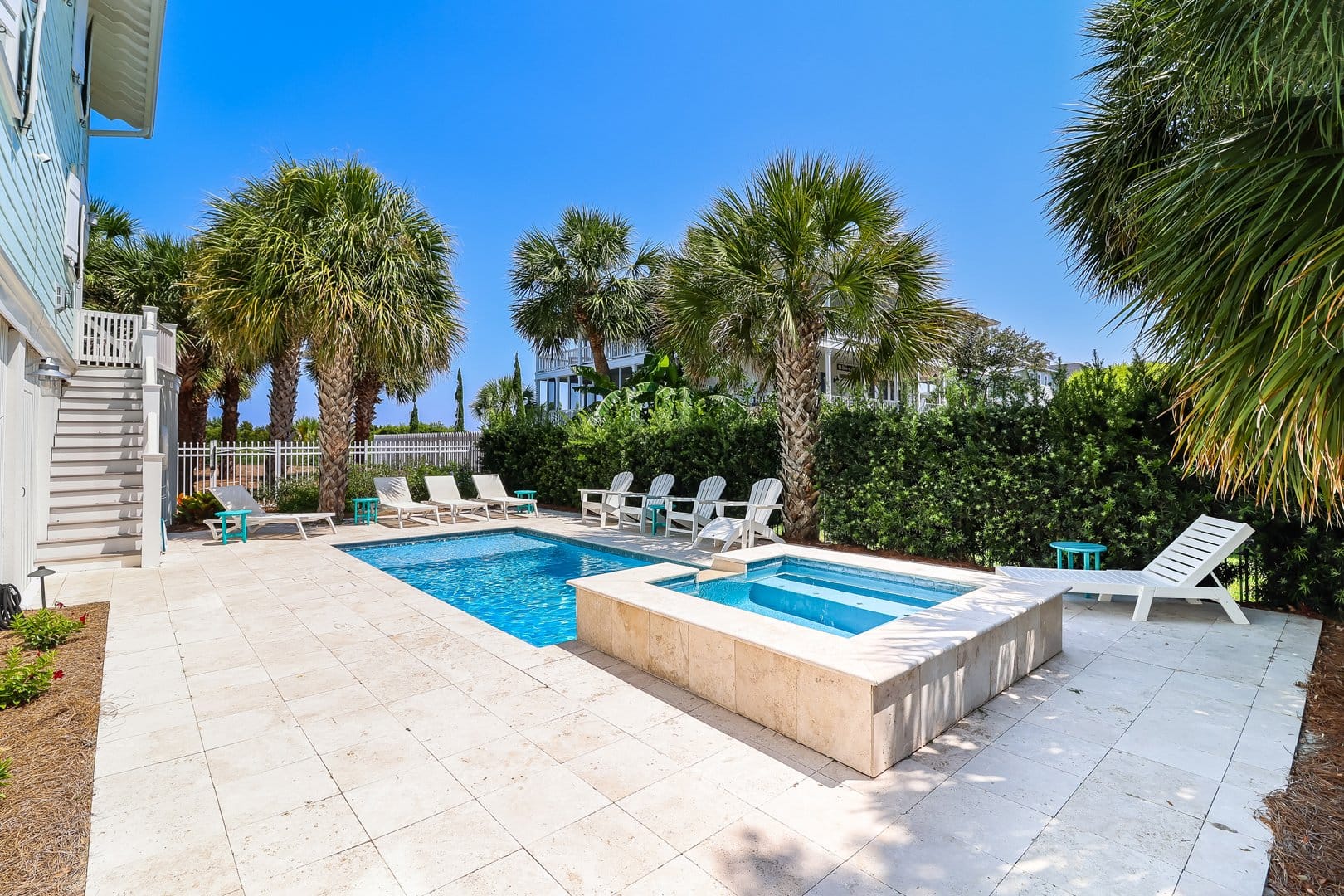 Pool area with loungers and palm trees.