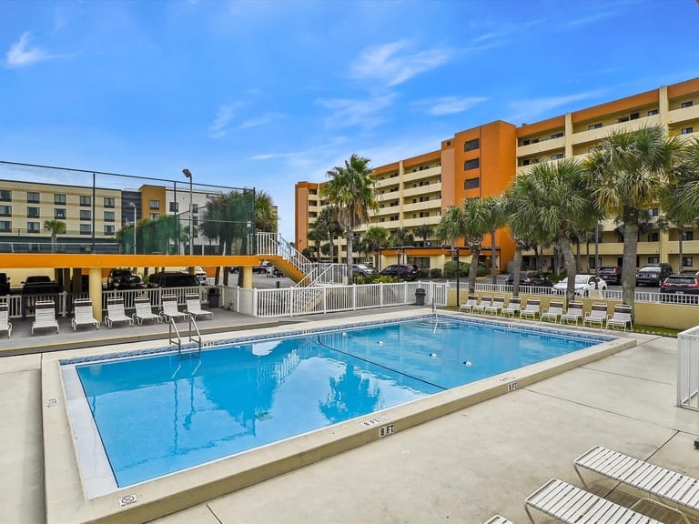 Outdoor pool with nearby buildings.