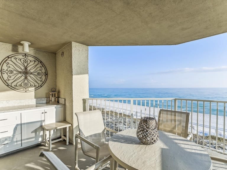 Balcony overlooking ocean, white furniture.