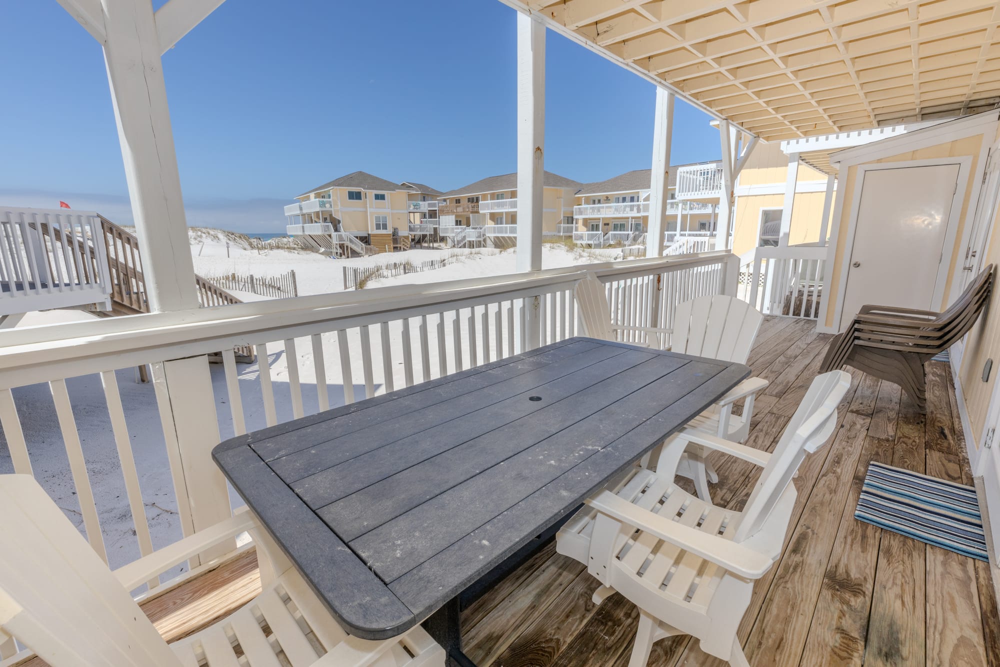 Beachside deck with table and chairs.