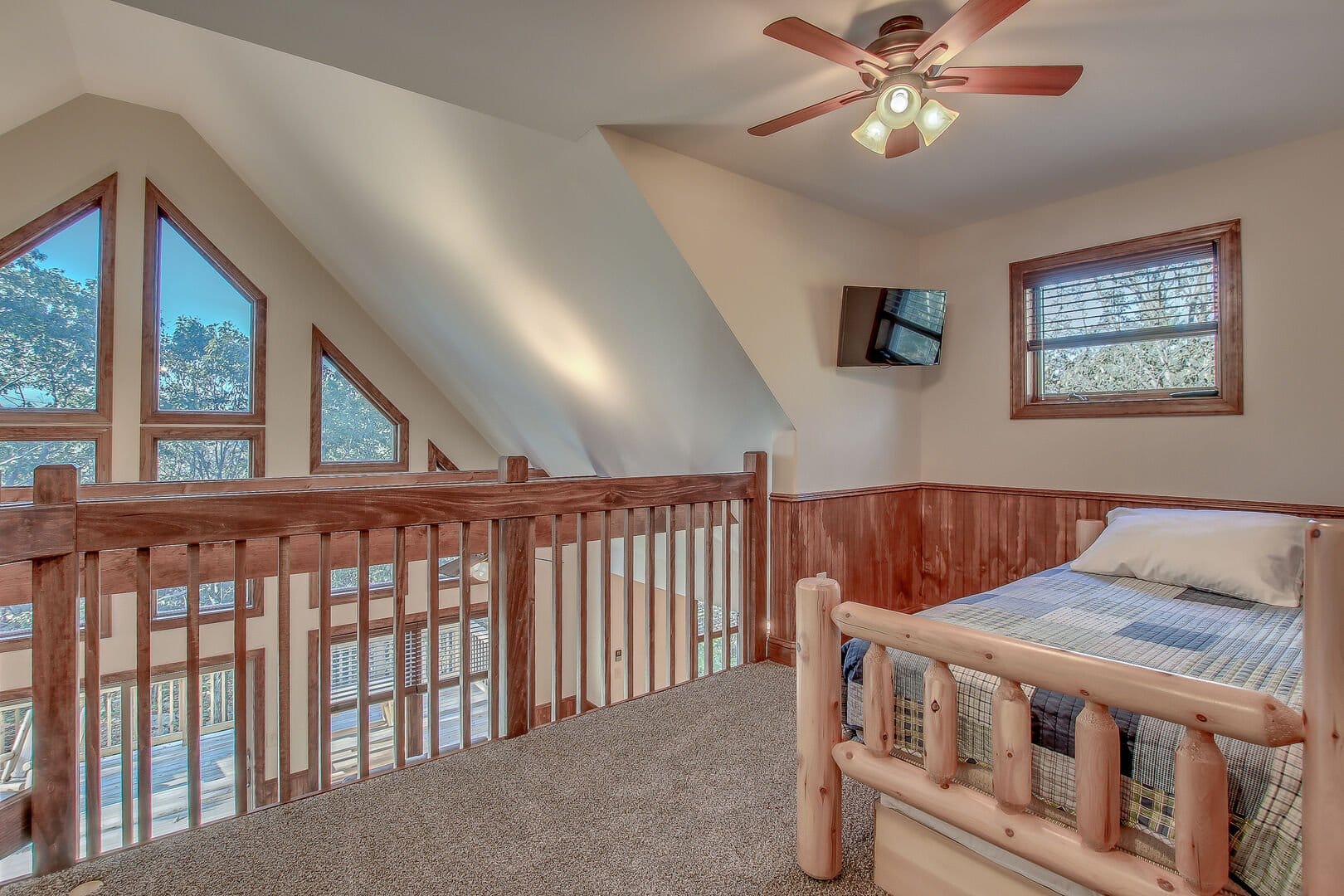 Loft bedroom with large windows.