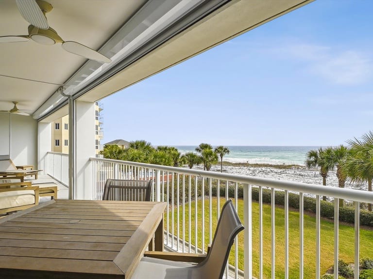 Balcony overlooking ocean and palm trees.