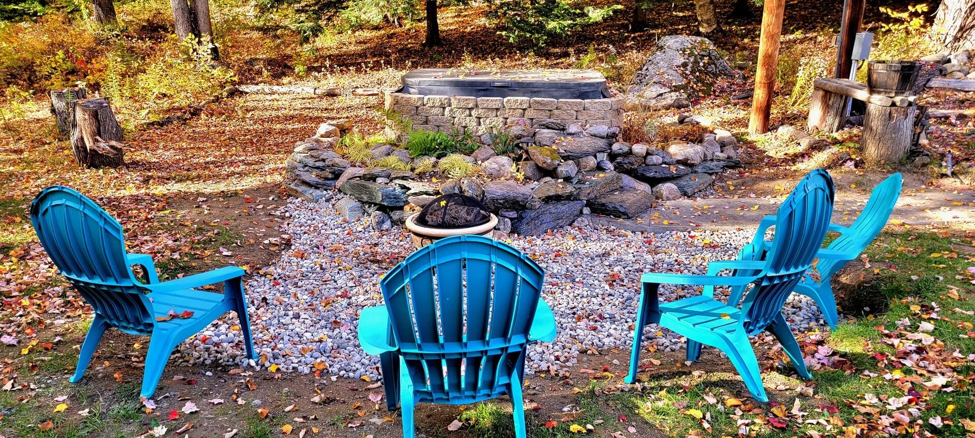 Blue chairs around backyard fire pit.