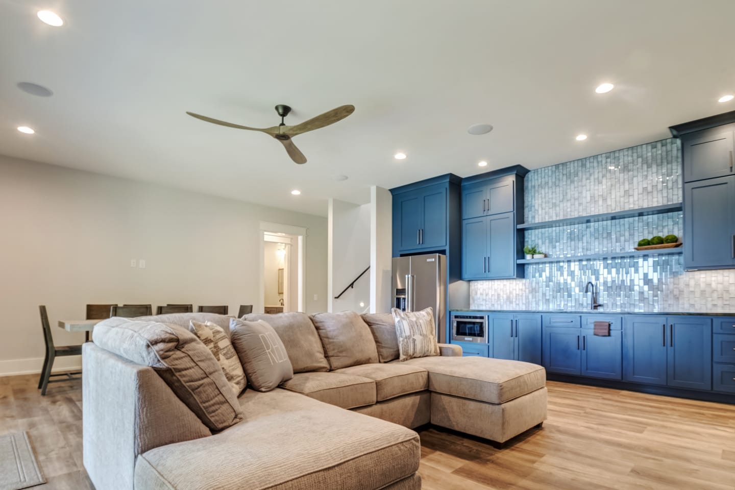 Modern living room with blue kitchen.