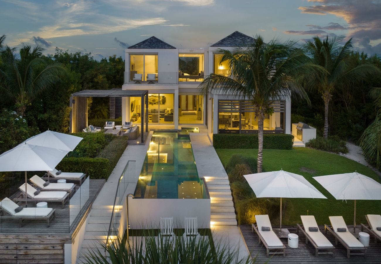 Modern villa with pool and loungers.