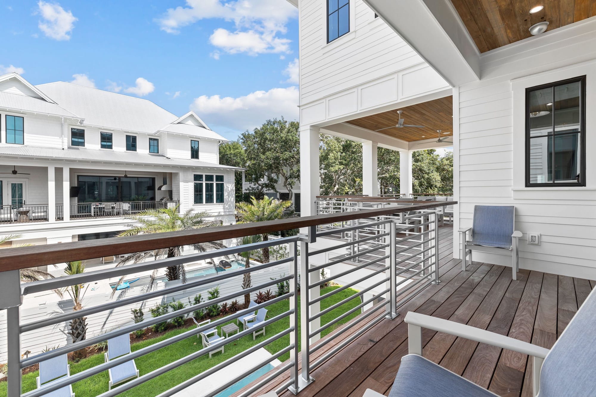 Modern balcony overlooking houses and pool.