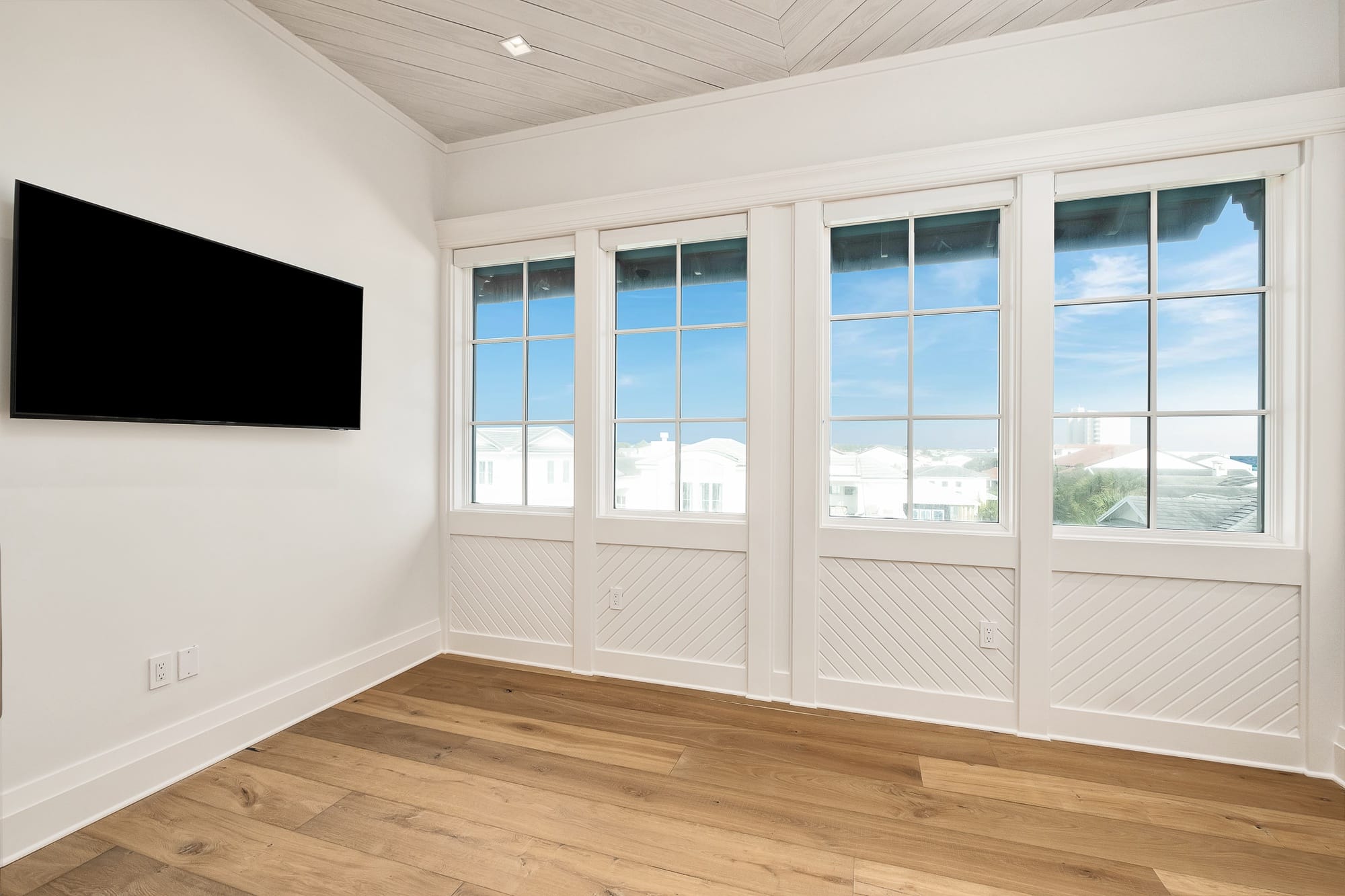 Room with windows and wall-mounted TV.