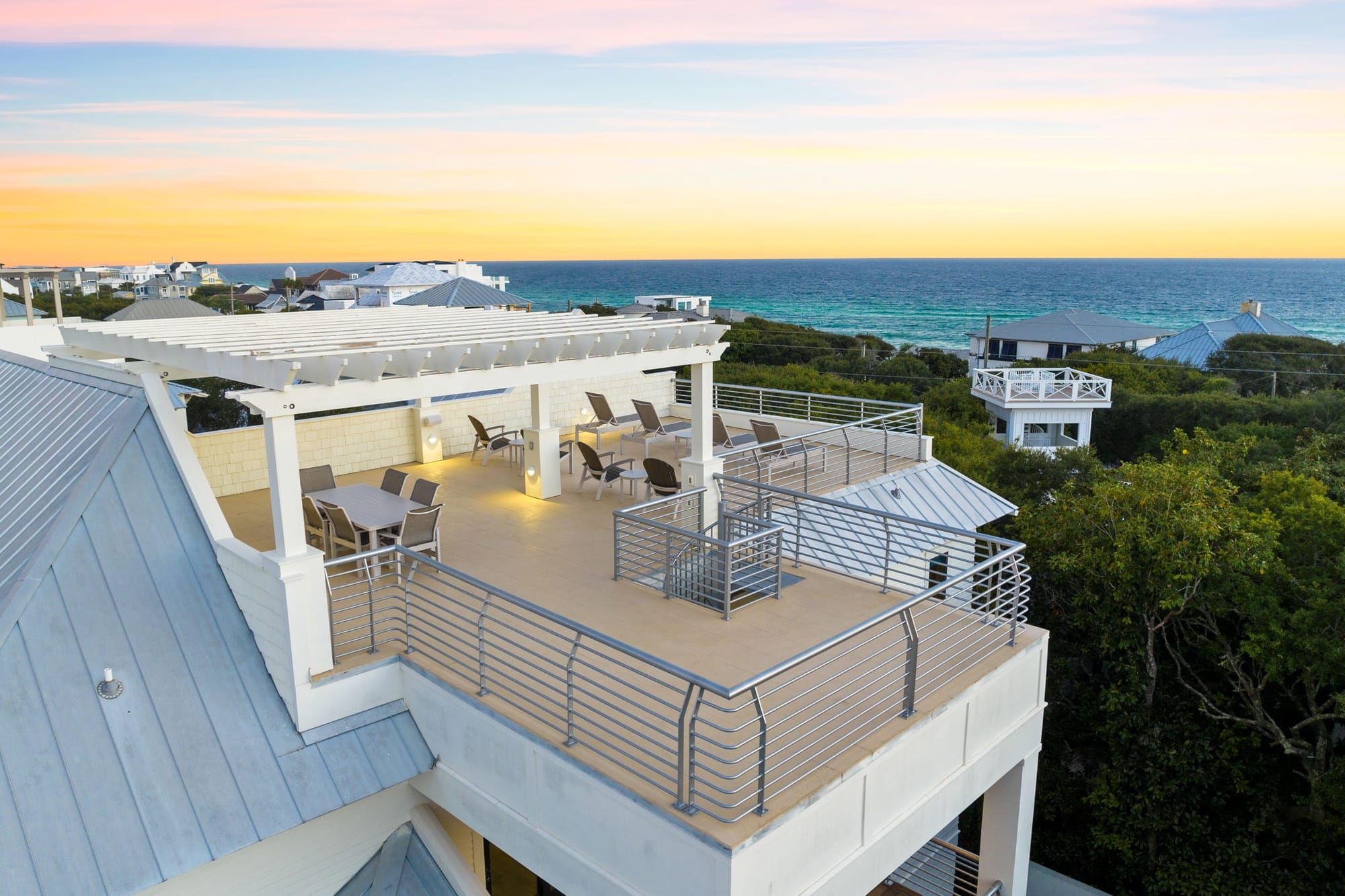 Rooftop patio overlooking ocean sunset.