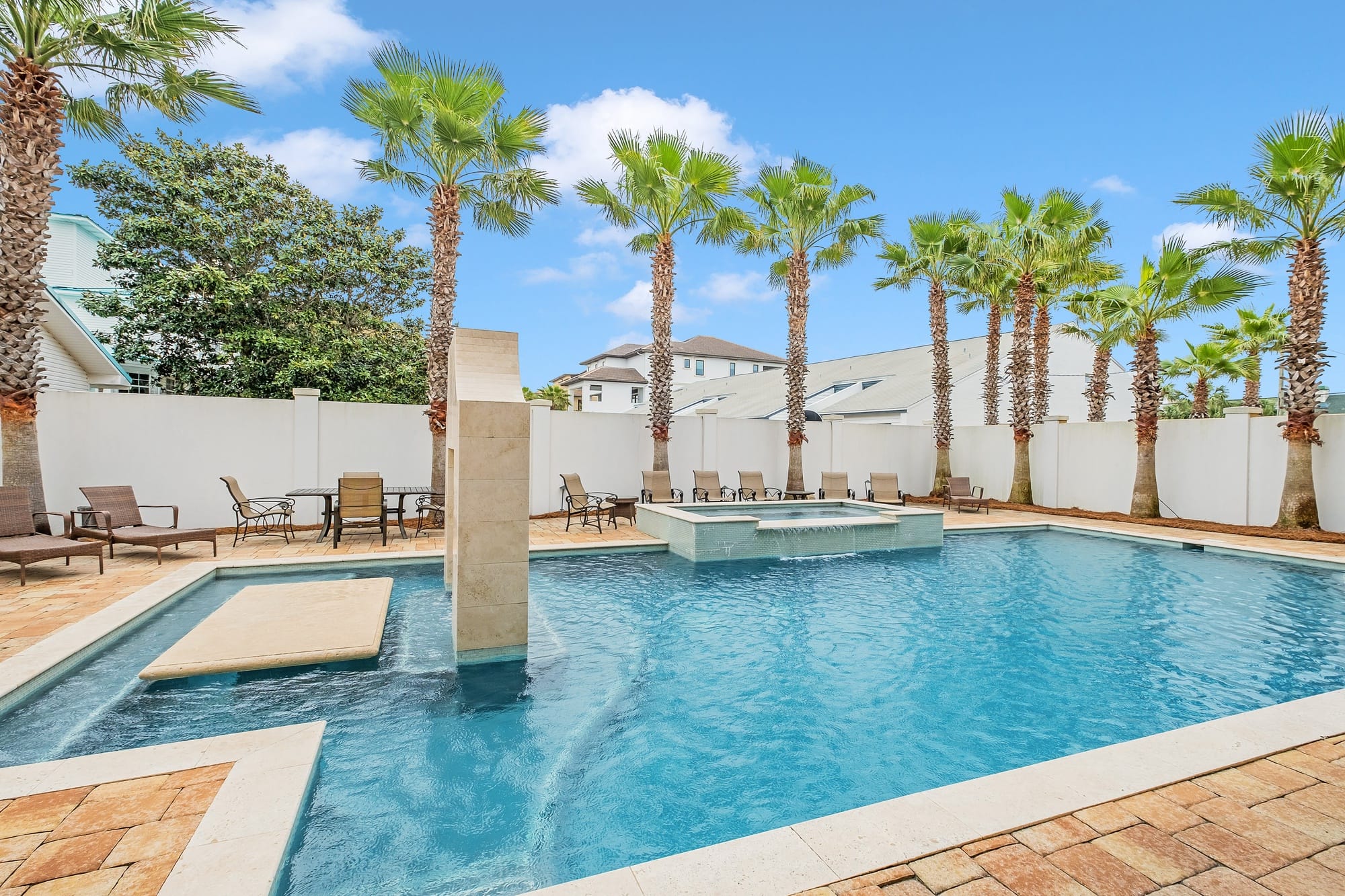 Pool with palm trees and loungers.