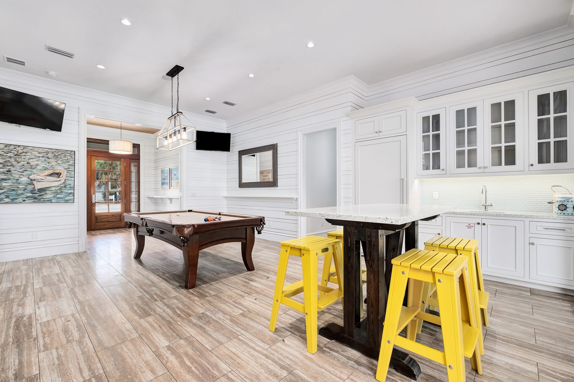 Game room with pool table, stools.