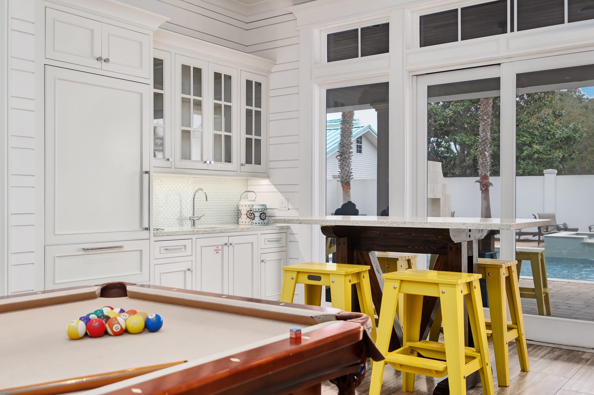 Kitchen with pool table and stools.