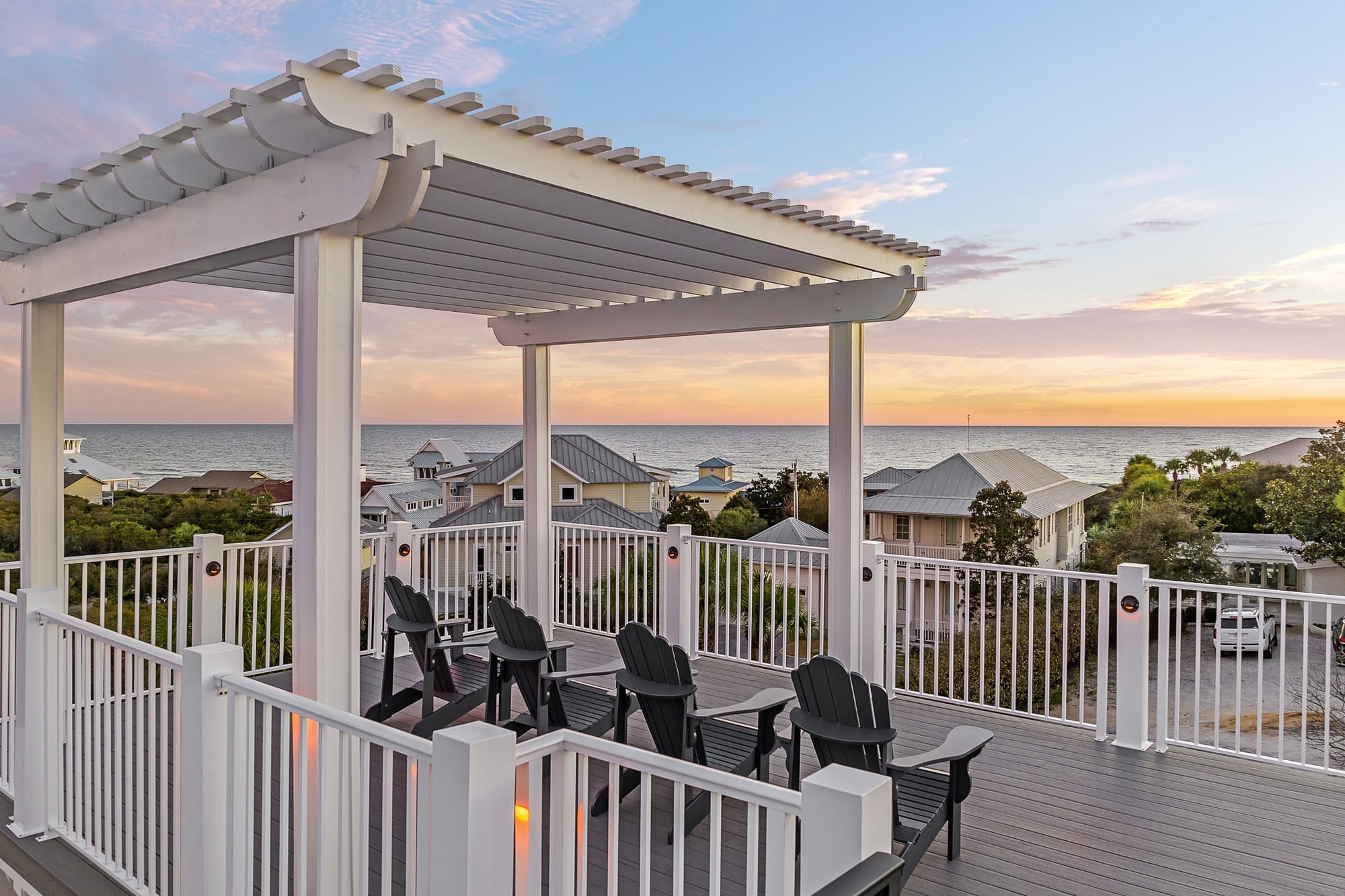 Rooftop deck overlooking ocean sunset.