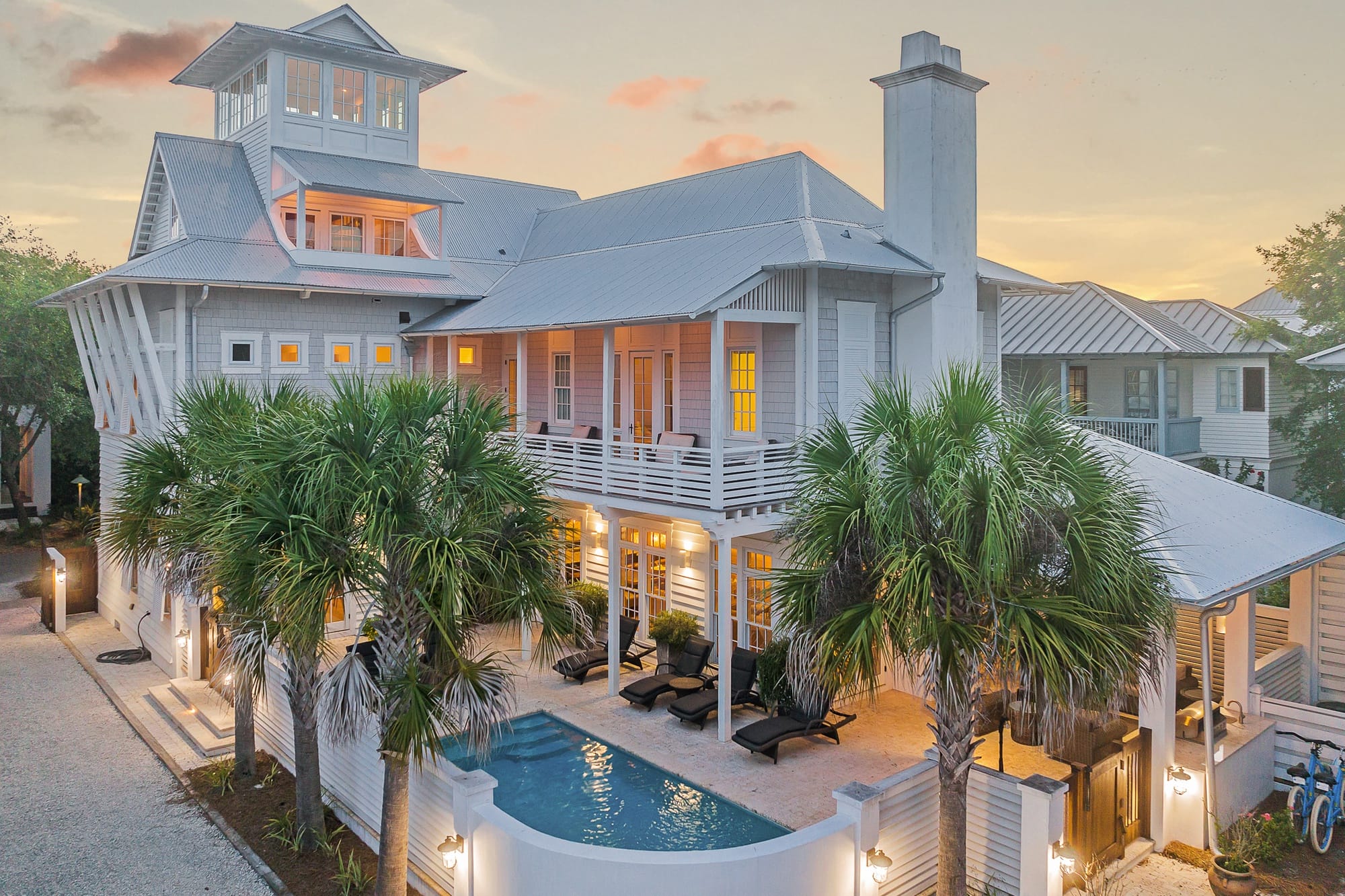 Beach house with pool, palm trees.